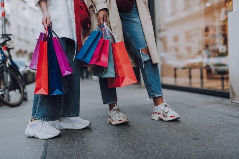 Young women with shopping bags standing on the street